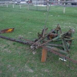 DSCF4528 - Montana Auctions by Kevin Hill Rusty old farm implement with long tines lying on a grassy field near a fence.