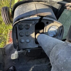 IMG_1305 - Montana Auctions by Kevin Hill Close-up of a dusty tractor dashboard with several round gauges and a bent steering column in a rural field cab.