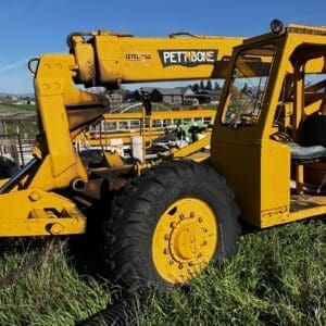 IMG_1346 - Montana Auctions by Kevin Hill Yellow telescopic handler/telehandler parked on grass with large tires and an extended boom in the foreground.