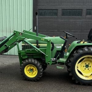IMG_1392 - Montana Auctions by Kevin Hill John Deere green tractor with front-end loader bucket parked in front of a green building.