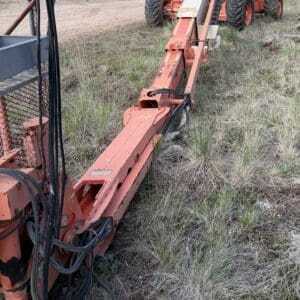 IMG_6542 - Montana Auctions by Kevin Hill Orange mobile conveyor extended across a grassy field, with a yellow wheeled processing unit in the background.