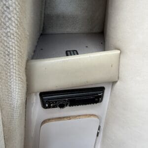 IMG_6559 - Montana Auctions by Kevin Hill Beige vehicle interior with a black in-dash stereo mounted in a panel and a small storage cabinet below the radio.