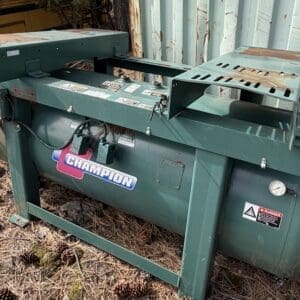 IMG_6584 - Montana Auctions by Kevin Hill Industrial green air compressor unit mounted on a metal frame outdoors, with warning labels and a pressure gauge visible.