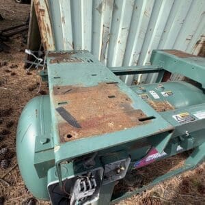 IMG_6586 - Montana Auctions by Kevin Hill Rusted teal industrial machine frame outdoors beside a corrugated metal wall, with an open electrical panel and exposed wiring.