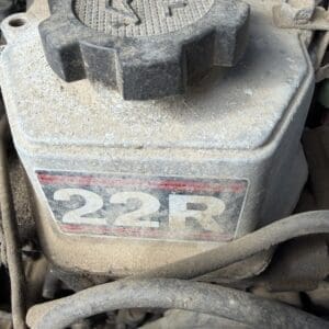 IMG_6614 - Montana Auctions by Kevin Hill Oil filler cap labeled OIL on a dusty engine top with a 22R badge nearby.