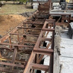 IMG_6623 - Montana Auctions by Kevin Hill Rusted steel truss framework extending over a concrete edge in an outdoor storage yard.