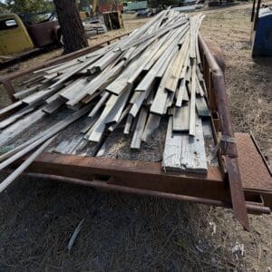 IMG_6654 - Montana Auctions by Kevin Hill Stack of weathered metal studs and wooden planks piled on a rusted trailer in a junkyard outdoor yard setting.