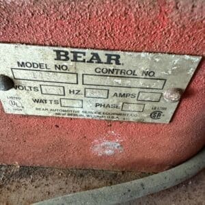 IMG_6659 - Montana Auctions by Kevin Hill Close-up of a dusty red industrial motor with a metal BEAR nameplate showing fields for model number, control number, volts, Hz, and amps.