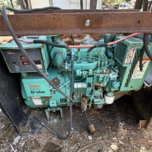 IMG_6666 - Montana Auctions by Kevin Hill Teal Onan 7.5RV GenSet generator engine mounted in a rusty metal frame outdoors.