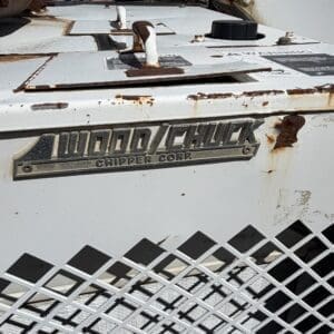 IMG_6712 - Montana Auctions by Kevin Hill Close-up of a rusty Wood Chuck Chipper Corp. wood chipping machine with a diamond metal grate in the foreground.