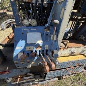 IMG_6768 - Montana Auctions by Kevin Hill Blue, rusted control panel of heavy equipment with levers, gauges, and warning labels visible.