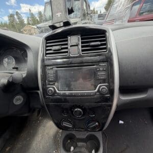 IMG_6777 - Montana Auctions by Kevin Hill Dusty car interior focusing on center console, gear shifter, and cup holders, with a suction-mounted device on the windshield above the dash,”