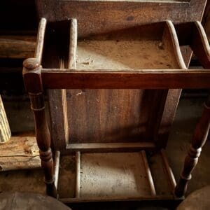 Dusty antique wooden vanity with a mirror and open drawers.