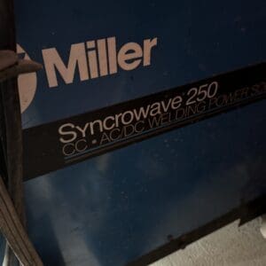Close-up of a Miller Syncrowave 250 welding power supply label on a blue unit