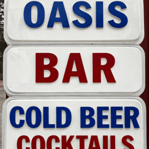 Three-panel sign advertising Oasis Bar offering cold beer and cocktails, with blue and red lettering.