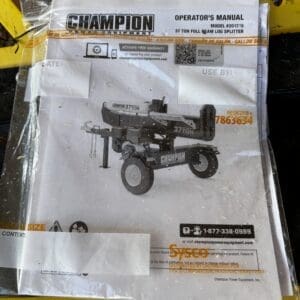 Operator's manual for a Champion 37-ton log splitter placed on a yellow metal grate fence area outside, visible model number and barcodes.