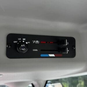 Vehicle overhead climate control panel with A/C, temperature slider, and fan indicators