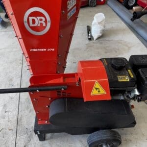 Red DR Premier 375 wood chipper in a workshop, with engine and wheels visible in the foreground.