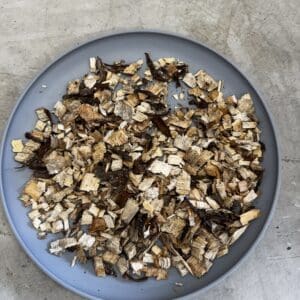 Blue plate filled with assorted wood chips and shavings on a gray surface background.